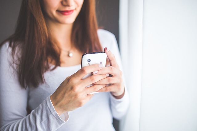 携帯電話でメッセージを送っている女性